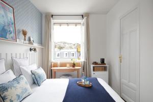 a bedroom with a bed and a window and a table at Le Flaubert in Trouville-sur-Mer