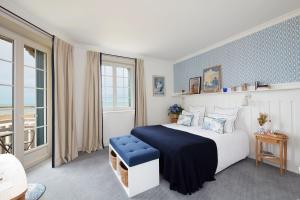 een slaapkamer met een groot bed met een blauwe muur bij Le Flaubert in Trouville-sur-Mer