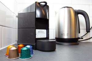 a kitchen counter with a coffee maker and a tea kettle at GERARD WALK - Spacious Home, High Speed Wi-Fi, Free Parking, Garden in Swindon