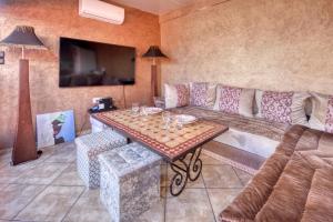 a living room with a couch and a table at Riad Palmi magnifique Riad centre ville - 6px in Agadir