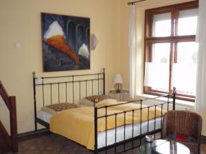 een slaapkamer met 2 bedden en een schilderij aan de muur bij Pension Stará Škola in Hrubá Skála