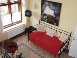 赫魯巴斯卡拉的住宿－Pension Stará Škola，一间卧室配有红色的床和电视