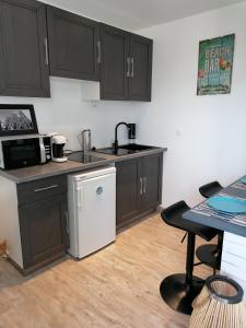 a kitchen with brown cabinets and a sink and a table at Studio Anoe in Nice +7 photos