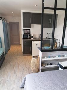 a kitchen with black cabinets and a bed in a room at Studio Anoe in Nice