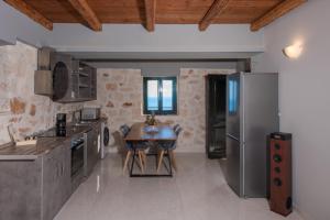 a kitchen with a table and a stainless steel refrigerator at Xigia Escape villas in Khartáta