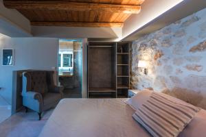 a bedroom with a large bed and a chair at Xigia Escape villas in Khartáta