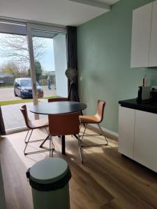 een keuken met een tafel en stoelen in een kamer bij Vakantie vieren aan het Sneekermeer in Offingawier