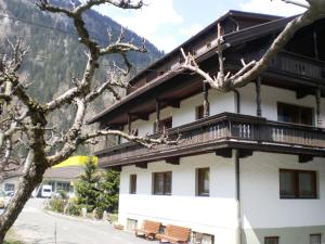 - un grand bâtiment avec un balcon sur le côté dans l'établissement Bergsteiger-Zimmer Pension Obermair, à Mayrhofen