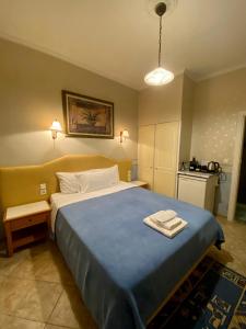 雅典的住宿－Arma Faliro Rooms，一间卧室配有一张带蓝色毯子的大床