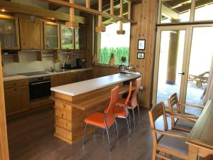 a kitchen with a counter with orange chairs in it at MAGNET - private chalet in Razlog