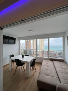 a living room with a table and chairs and a large window at Hany apartment Ducado 11-C in Benidorm
