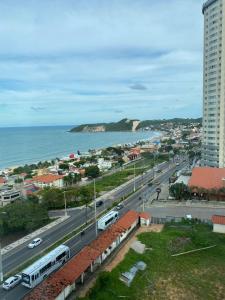 a view of a city with a street and the ocean at Ponta Negra Flat ByHotéis in Natal