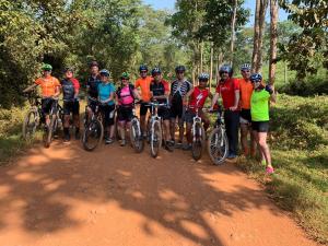 a group of people standing on a dirt road with bikes at Mwamba Kelele Lodge in Kasenda +65 photos