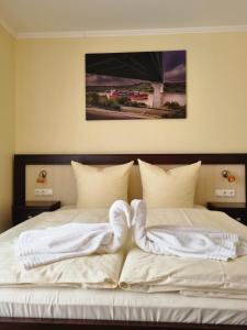 a bedroom with two beds with white sheets at Hotel O'felder in Osterrönfeld