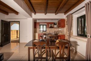 a kitchen with a wooden table and chairs at Xigia Escape villas in Khartáta