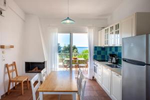 a kitchen with a table and a dining room at Alterra Vita Homes By the Sea in Neos Marmaras