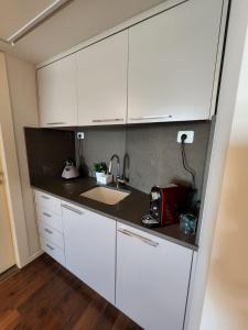 a kitchen with white cabinets and a sink at סוויטה בבעלות פרטית במלון מלכת שבא in Eilat