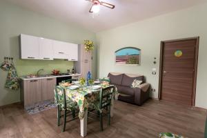 a kitchen and living room with a table and a couch at A Ficurigna in Marsala