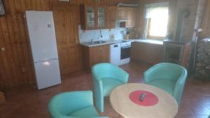 a kitchen with a table and chairs and a table and a refrigerator at Chata s bazénem Bozkov in Bozkovska