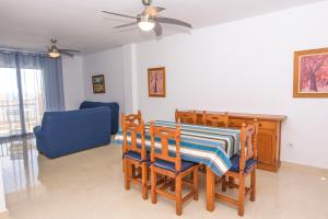 a dining room with a table and chairs and a blue couch at Miramar - Goya in Carboneras +10 photos