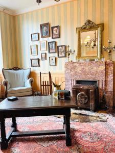 a living room with a table and a fireplace at Les 3 Gamins in Boussac