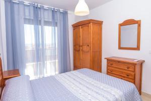 a bedroom with a bed and a dresser and a window at Miramar - Goya in Carboneras
