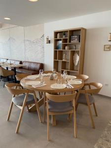 a dining room with a wooden table and chairs at Hôtel L'Albatros in Saint-Trojan-les-Bains