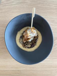 a blue bowl of food with a wooden spoon in it at Hôtel L'Albatros in Saint-Trojan-les-Bains