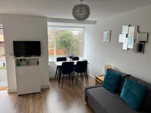a living room with a couch and a table with chairs at Comfy 2 bed house located at Wareham train station in Wareham