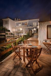 a wooden table and chairs on a patio at night at Ocean House Alentejo in Porto Covo