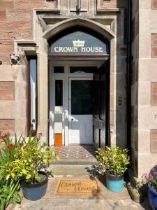 une porte d'entrée d'une maison brune avec un panneau sur celle-ci dans l'établissement Crown House, à Inverness