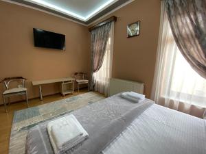 a bedroom with a bed and a tv and a window at Vila A Hotel in Korçë