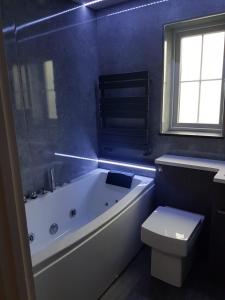 a bathroom with a white tub and a toilet at Double Room next to Burnham Elizabeth Line Station in Slough