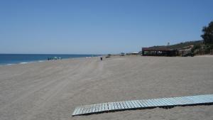 a beach with a surfboard laying on the sand at Don Juan Beach Resort in Estepona