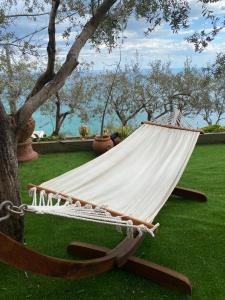 a hammock sitting on the grass next to a tree at Villa Pina in Praiano