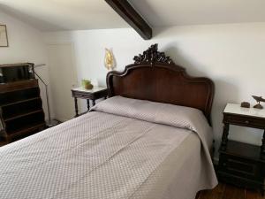 a bedroom with a large bed with a wooden headboard at Casa Delft in Furnas