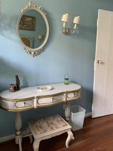 a dressing table with a mirror on a blue wall at Casa Delft in Furnas