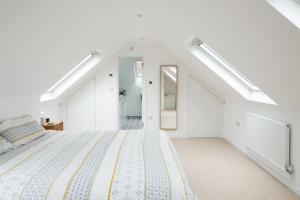 um quarto branco com uma cama e uma escada em Beautiful countryside home, 10min drive to Bath em Limpley Stoke