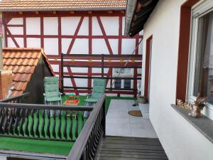 a balcony of a house with green chairs at Ferienwohnung am Krayenberg in Kieselbach