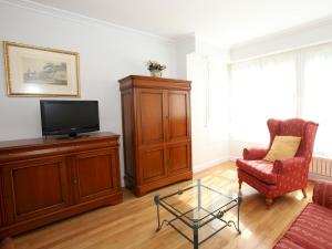 a living room with a tv and a chair at Apartamento Ondarreta in San Sebastián