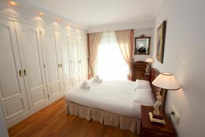 Un dormitorio con una gran cama blanca y una ventana en Apartamento Ondarreta, en San Sebastián
