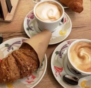 stół z dwoma talerzami jedzenia i dwoma filiżankami kawy w obiekcie Le Dimore dell'Acqua w mieście Matera