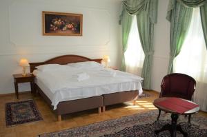 a bedroom with a bed and a chair and window at Hotel Renesance Krasna Kralovna in Karlovy Vary