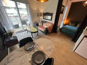 a living room with a table and a bedroom at Le Trendy in Les Gaudinais