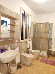 a bathroom with a sink and a toilet and a shower at B&B Siciliò in Santa Flavia