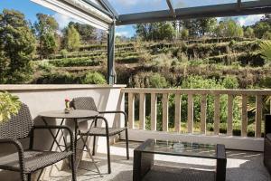 eine Terrasse mit Stühlen und Tischen und Blick auf einen Hügel in der Unterkunft Casa da Cevidade in Melgaço