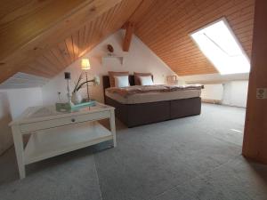 a bedroom with a bed and a table in a attic at Ferienwohnung am Krayenberg in Kieselbach