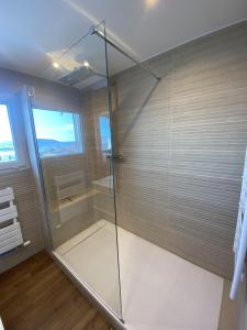 La salle de bains est pourvue d'une douche avec une porte en verre. dans l'établissement la Goelette, à Toulon