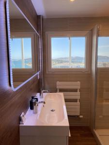 a bathroom with a sink and two windows at la Goelette in Toulon