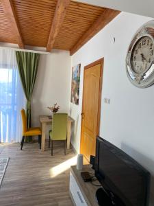 a living room with a tv and a clock on the wall at Vidikovac BIJELO POLJE in Bijelo Polje